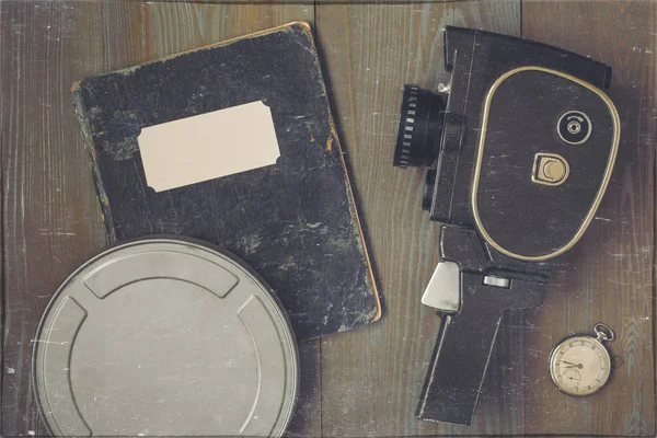 Una cámara de cine, un reloj, una caja de película y un viejo cuaderno — Foto de Stock