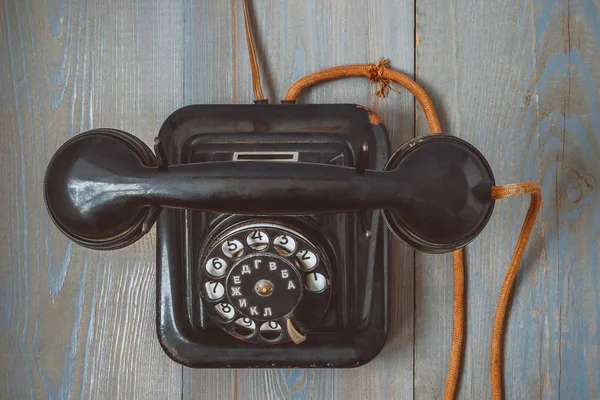 Gammal svart telefon med trasa sladd och rund urtavla — Stockfoto