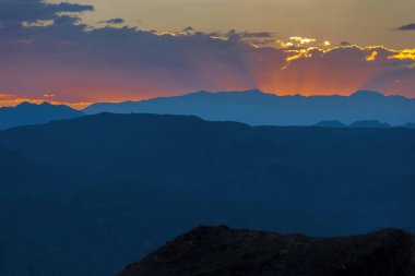 Sakin bir yaz akşamıydı. Dağların eteklerinde batan güneşin ışınlarıyla.