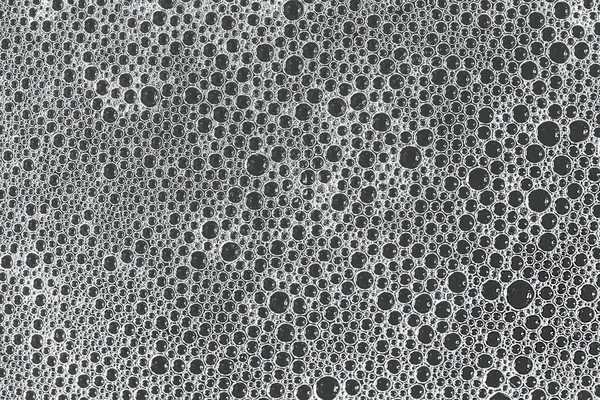 Soap bubbles texture shot from above close up. Black and white photo.