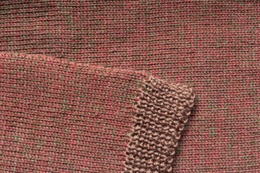 Örülmüş kahverengi bir arka planda örülmüş kahverengi bir kol.