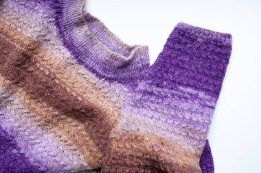 Beyaz arka planda mor kahverengi kollu ve kazaklı.