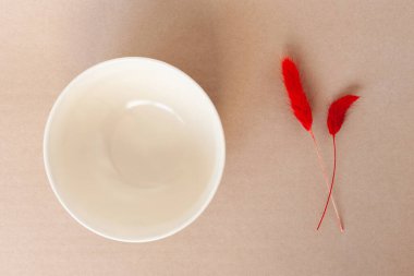 kırmızı kurutulmuş doğal çiçek buketleri Lagurus ovatus ve bej rengi arka planda yuvarlak kase.