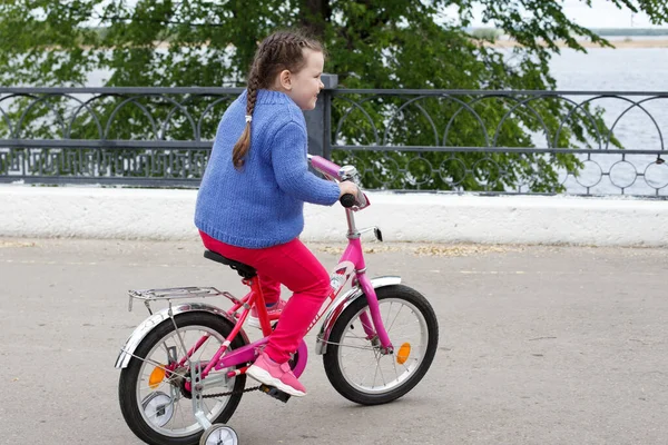 Una Ragazza Con Maglione Blu Pantaloni Rosa Guida Una Bicicletta — Foto Stock