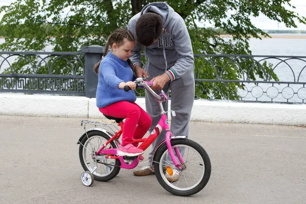 Papà Insegna Figlia Andare Bicicletta Rosa Sulla Riva Del Fiume — Foto Stock