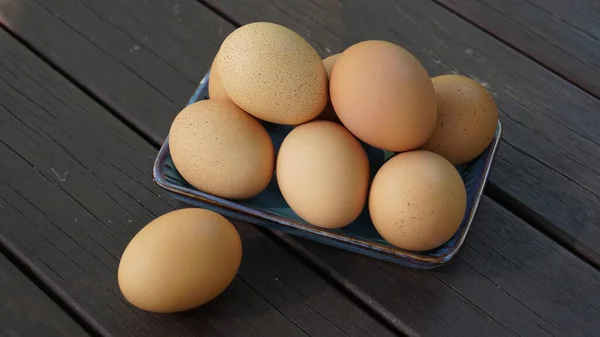 Een Stapel Eieren Een Bord Een Donkerbruine Tafel — Stockfoto