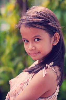 Doğadaki, parktaki ya da dışarıdaki gülümseyen küçük sevimli kızın portresi.