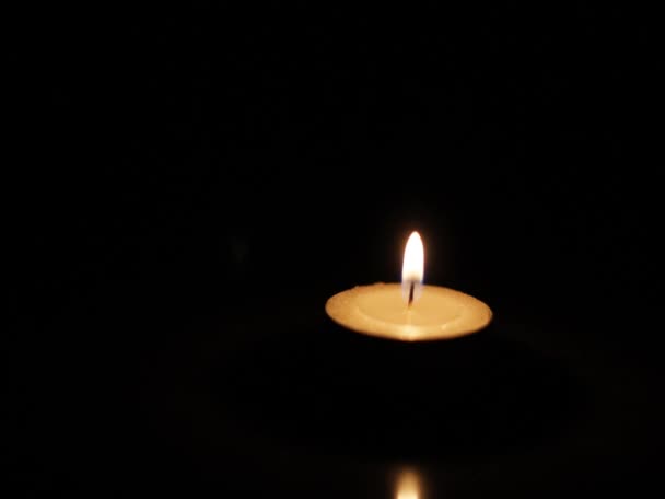 Dans un fond sombre, il y a une bougie 