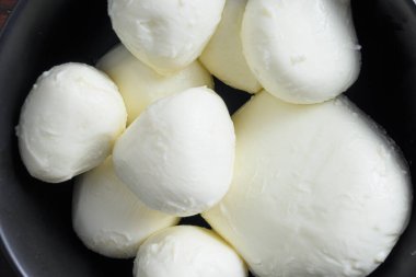 Eski ahşap arka planda çiğ Mozzarella bufalo peyniri topları. Seçici odağı kapat.