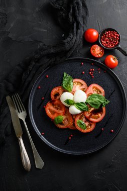 Domates, fesleğen, mozzarella Caprese salatası, balzamik sirke ve zeytinyağı. Üst görünüm, Blkack Stone arkaplanı