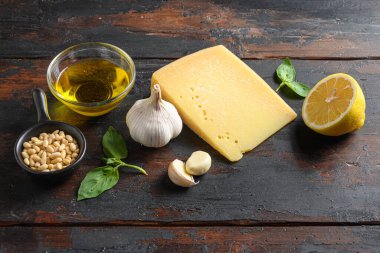 Parmesan peyniri, fesleğen, çam fıstığı, zeytin yağı, sarımsak, tuz ve biber hazırlayan yeşil fesleğen sosu İtalyan tarifi. Tahta masa kenarında..