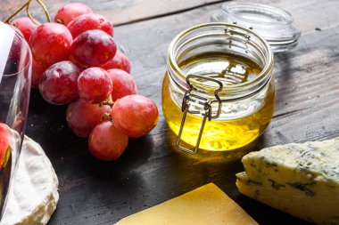 Kavanozda bal seçici odaklı üzüm ve Fransız küflü peyniri yakın çekim..