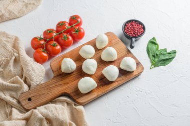 Küçük mozzarella peyniri topları, salata Caprese için ahşap malzeme üzerinde. Beyaz arka planda. Üst görünüm.