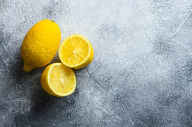Tam ve litresi yarım meyve limonu ve gri arkaplanda metin için boşluk.