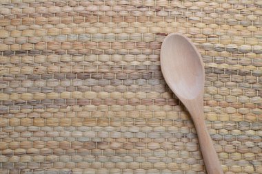 Geleneksel hasır kumaşa yerleştirilmiş tahta kaşık kurutulmuş saplı su sümbülü ya da Eichhornia crassipes. Kopyalama alanı olan üst görünüm.