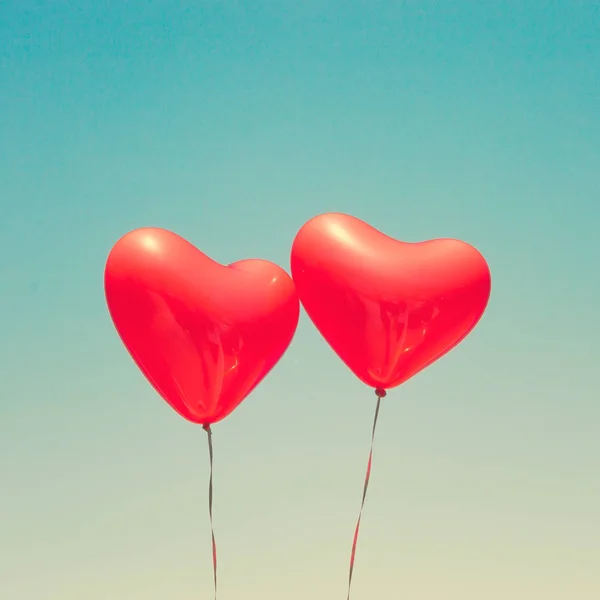 Two red heart shaped balloons