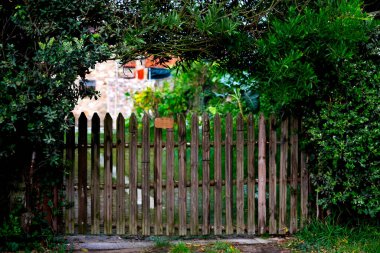 garden design. authentic old wooden gate entrance to the garden. cozy little fence with green bus clipart