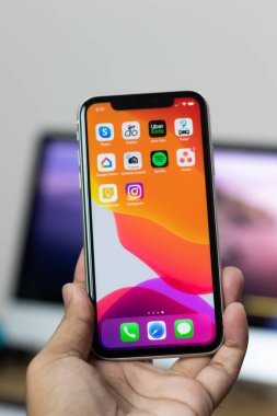 iPhone 11 'in arkası. Elinde beyaz varyant.