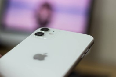 iPhone 11 'in arkası. Elinde beyaz varyant.