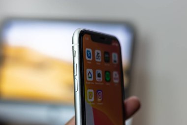 iPhone 11 'in arkası. Elinde beyaz varyant.