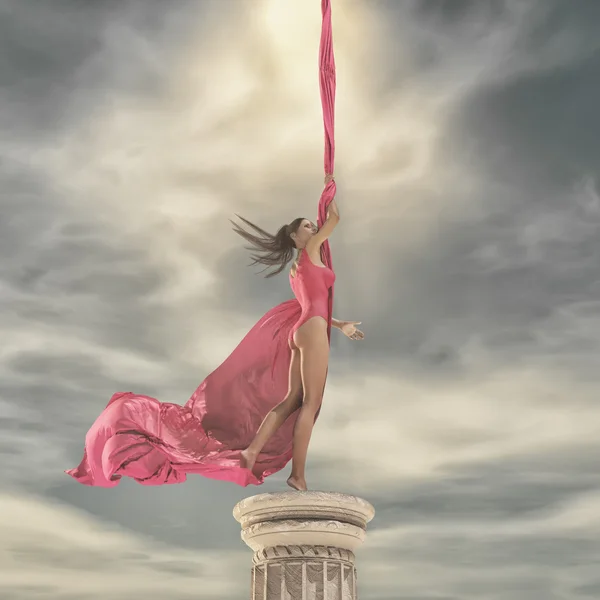 Beautiful girl standing  up on a column — Stock Photo, Image