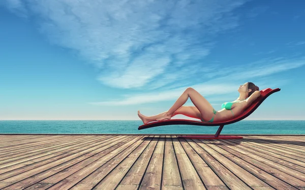 Frau auf einer Sonnenliege am Strand — Stockfoto