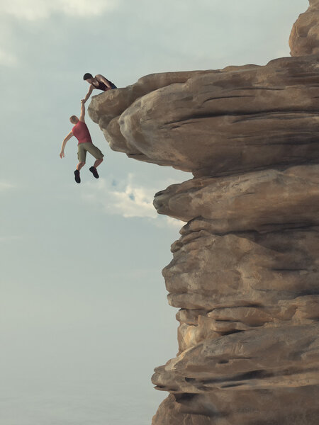 Молодой человек протягивает руку альпинисту
