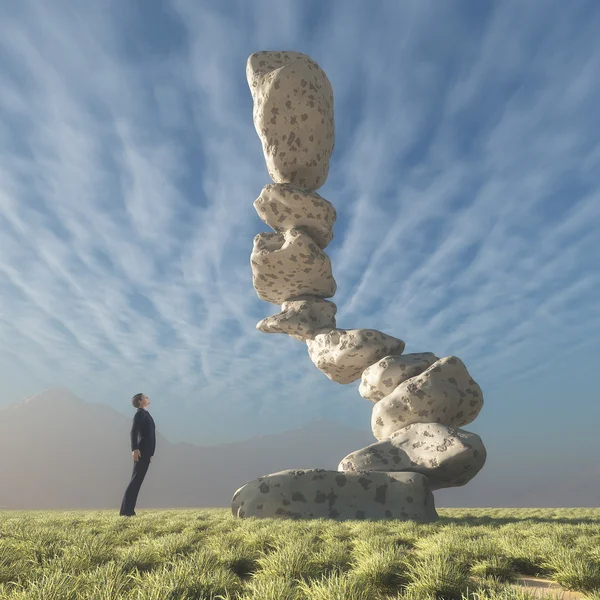 Mann blickt auf Felsen, die ins Gleichgewicht gebracht wurden. — Stockfoto