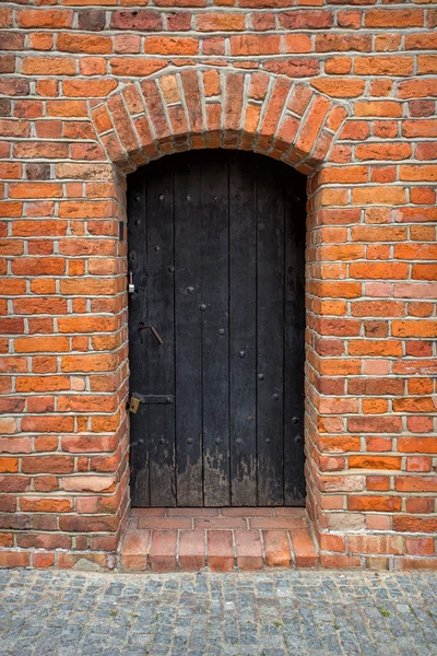 Vörös téglafal és a fa zárt ajtó — Stock Fotó