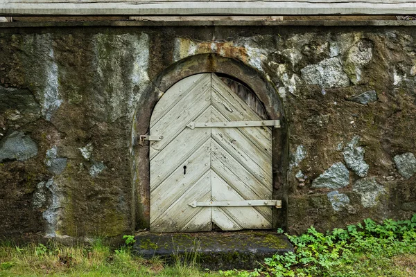 Древняя деревянная дверь в каменной стене замка — стоковое фото