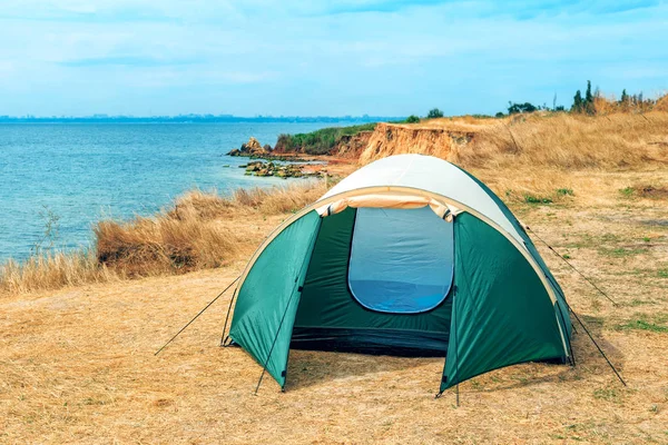 Tent on the hill beneath the mountains under dramatic sky — Stock Photo, Image