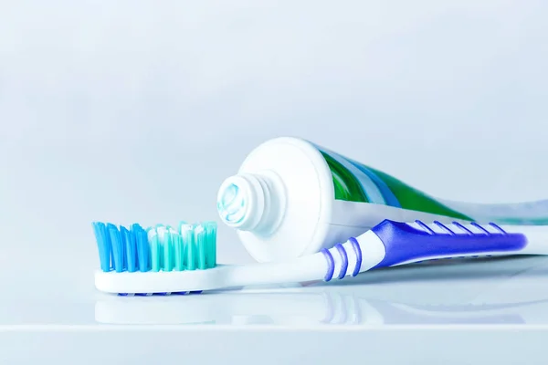 Zubní kartáček a zubní pasta na rozmazaném pozadí — Stock fotografie