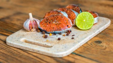 Ahşap kesme tahtası üzerinde ham Marine alabalık filetosu. Biftek somon kızartma için hazır