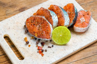 Ahşap kesme tahtası üzerinde ham Marine alabalık filetosu. Biftek somon kızartma için hazır