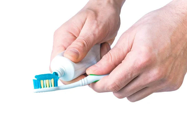 Зубная паста и кисть в руках мужчин, изолированных на белом — стоковое фото