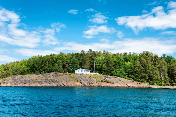 Pequeña casa tradicional noruega cerca del mar con bosque verde en las montañas —  Fotos de Stock