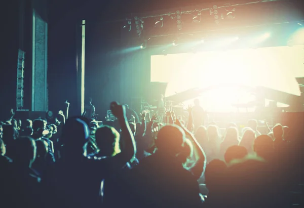 Parlak sahne ışıkları önünde konser kalabalığının siluetleri — Stok fotoğraf