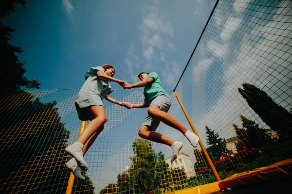 Pár jumping a trambulin-a parkban — Stock Fotó