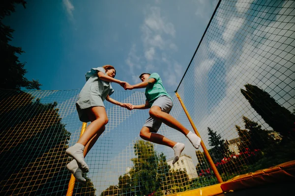 Pár, skákání na trampolíně v parku — Stock fotografie