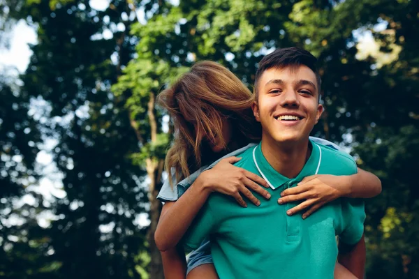 Homem carrega uma menina em suas costas — Fotografia de Stock