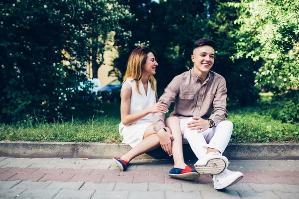 Man and woman sitting on the curb — Stock Photo, Image