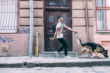 a köpek ile sokakta yürüyen adam