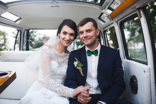 Невеста и жених сидят в машине — стоковое фото