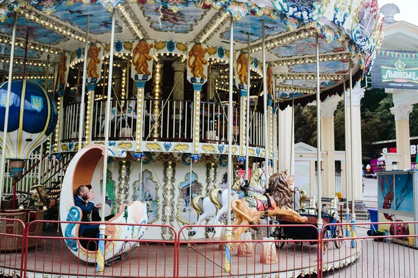 Volwassen man en vrouw op een carrousel — Stockfoto