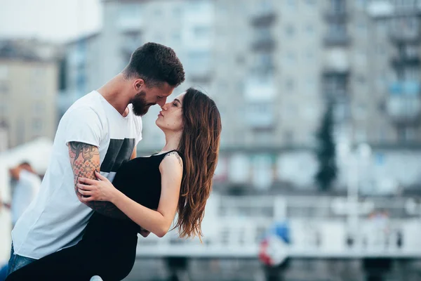 Casal beijando contra o pano de fundo da cidade — Fotografia de Stock