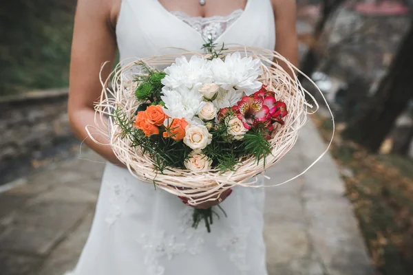 Braut hält Hochzeitsstrauß — Stockfoto