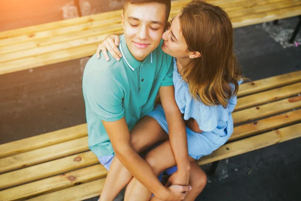 Killen och tjejen sitter på en bänk — Stockfoto