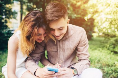 Ascot parkta oturan bir smartphone kullanarak