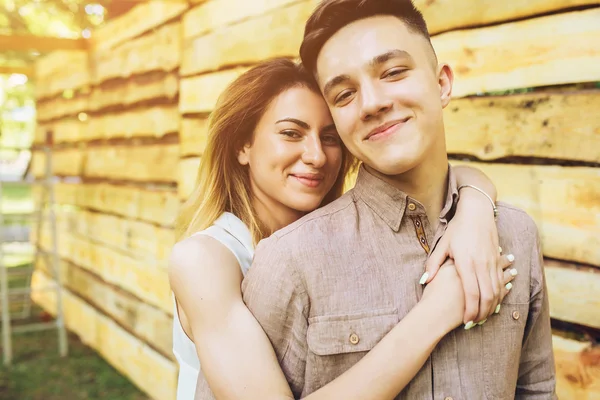 Couple posing on a background of the wooden wall — Stock Photo, Image