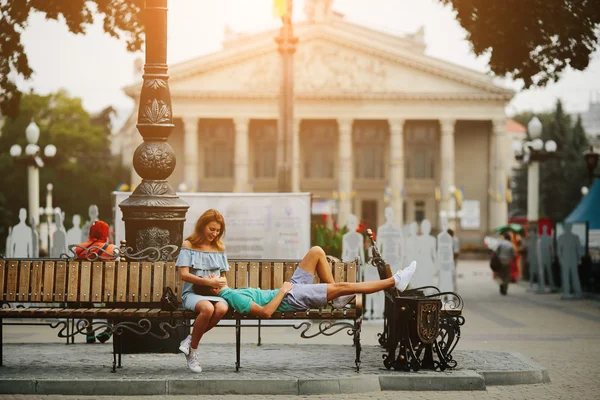 Guy and girl sitting on a bench — Stock Photo, Image